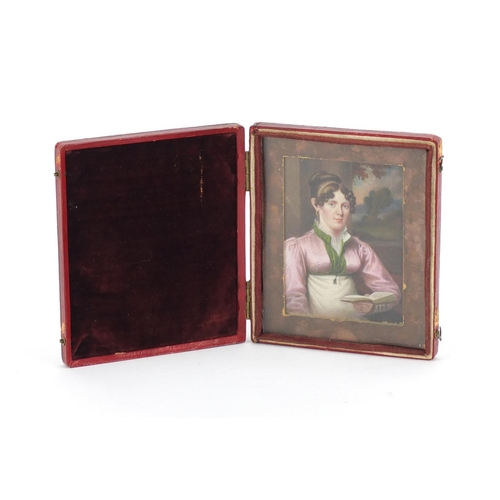 120 - Georgian hand painted portrait miniature of a female reading, mounted and housed in a red leather ca... 