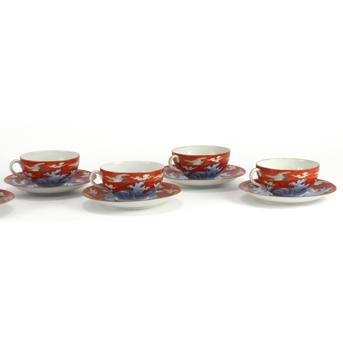 590 - Japanese porcelain cups and saucers hand painted with cranes amongst clouds, character marks to the ... 