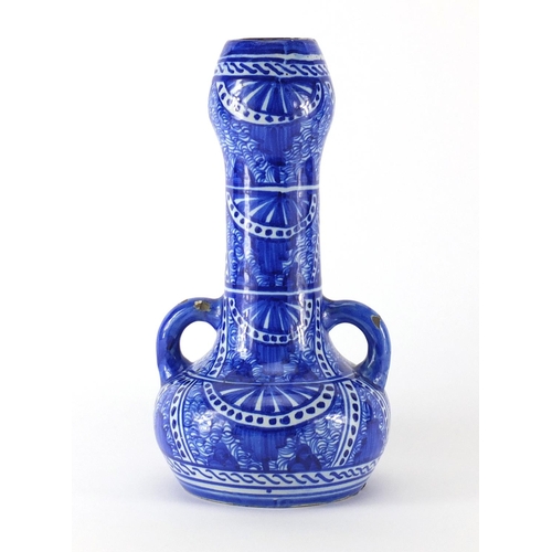 719 - Islamic pottery vase with twin handles, hand painted with stylised flowers, 32cm high