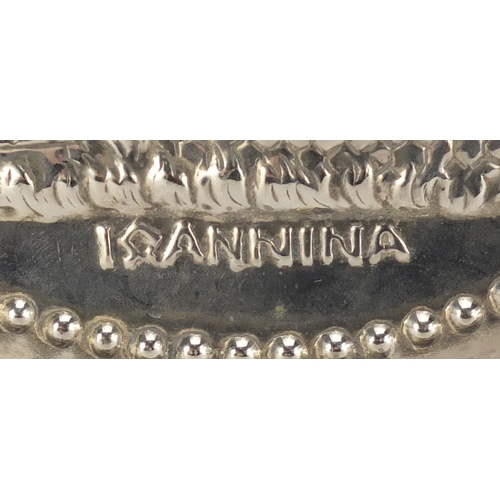 699 - Iranian silver coloured metal plate, embossed with a church within a foliate border, 28cm in diamete... 