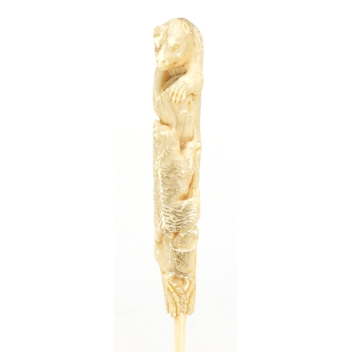 103 - Good 19th century ivory page turner, the handle finely carved with two bears climbing a trunk for ho... 