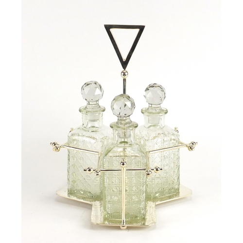 2262 - Modernist silver plated three bottle tantalus in the style of Christopher Dresser, housing three cut... 