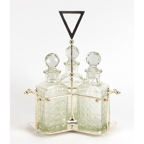 2262 - Modernist silver plated three bottle tantalus in the style of Christopher Dresser, housing three cut... 