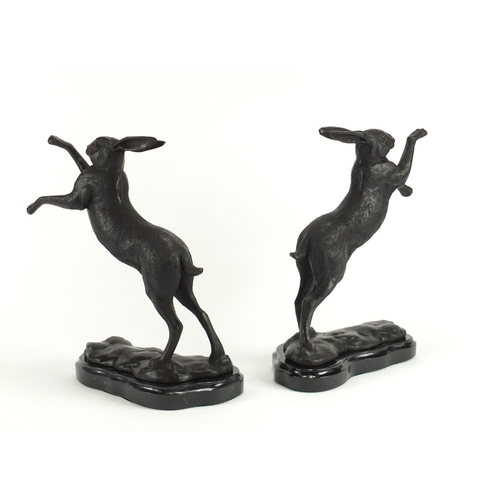 2175 - Pair of patinated bronze hares raised on shaped marble bases, each 29.5cm high
