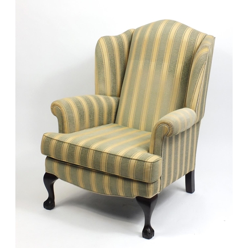 2083 - Mahogany framed wingback armchair with green and gold upholstery, raised on ball and claw feet, 108c... 