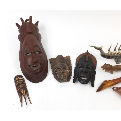 613 - African carved wood wall masks, a horn model boat and doll's chair