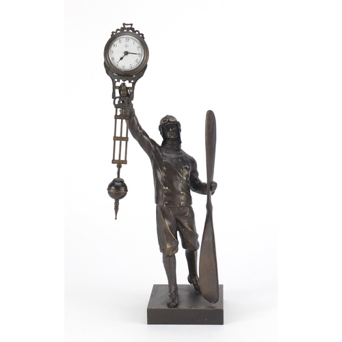 2348 - Military interest patinated bronze swinging clock in the form of a pilot holding a propeller, 38.5cm... 