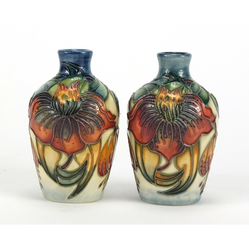 2255 - Pair of Moorcroft pottery vases hand painted with stylised flowers, each 9.5cm high