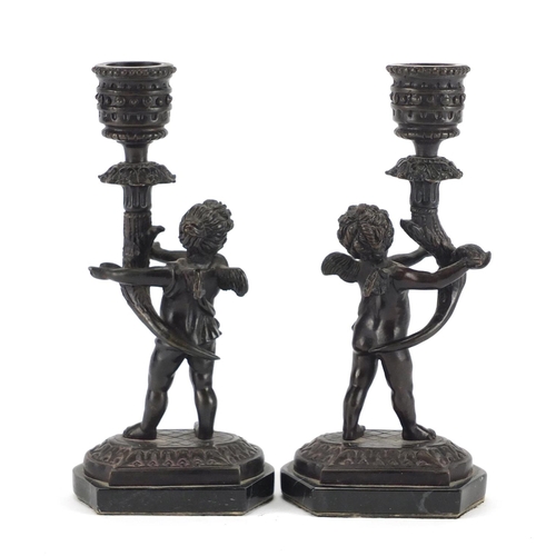 2358 - Pair of classical patinated bronze putti design candlesticks raised on marble bases, each 18cm high