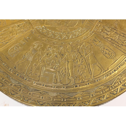 2063 - Arts & Crafts Egyptian Revival folding table, the brass top embossed with figures, 55cm high x 60cm ... 