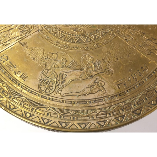 2063 - Arts & Crafts Egyptian Revival folding table, the brass top embossed with figures, 55cm high x 60cm ... 