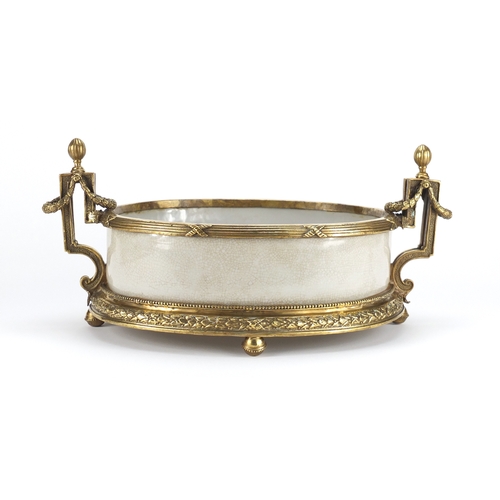 2209 - Four footed crackle glazed centre piece with twin handles, having ornate brass mounts, 42cm wide