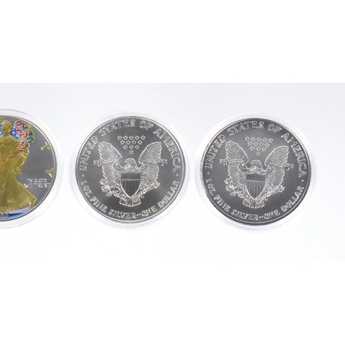 2702 - Four United States of America coloured silver dollars, with certificates comprising dates 2001, 2003... 