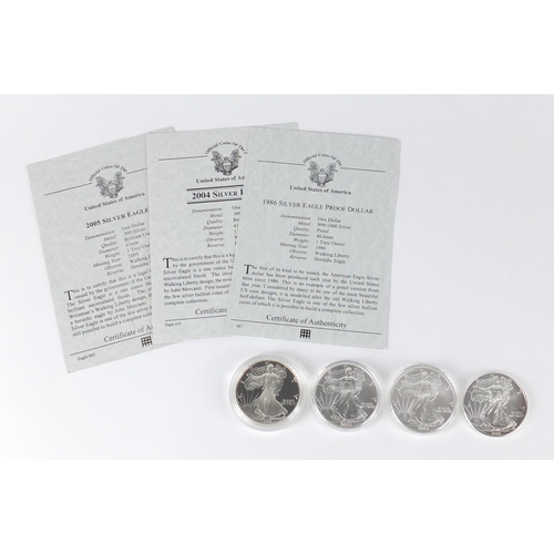 2708 - Four United States of America silver eagle dollars, three with certificates comprising dates 1986, 2... 