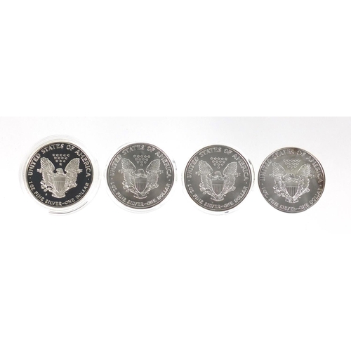 2708 - Four United States of America silver eagle dollars, three with certificates comprising dates 1986, 2... 