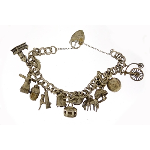 2824 - Silver charm bracelet with selection of mostly silver charms including a cow bell, windmill, woodpec... 