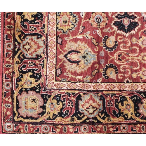 2047 - Rectangular Indian rug having an all over floral design onto a red ground, 223cm x 155cm