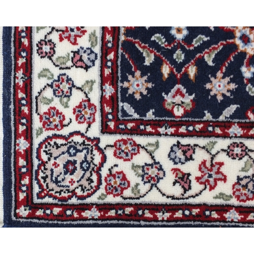 2072 - Rectangular persian rug having an all over floral design onto a blue and cream ground, 140cm x 92cm