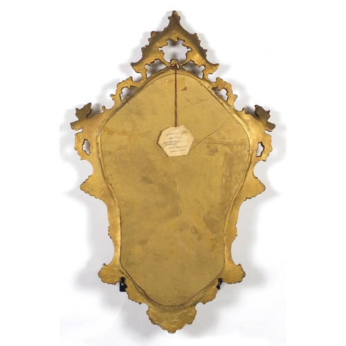 25 - Gilt framed cartouche shaped wall hanging mirror, 76cm x 48cm