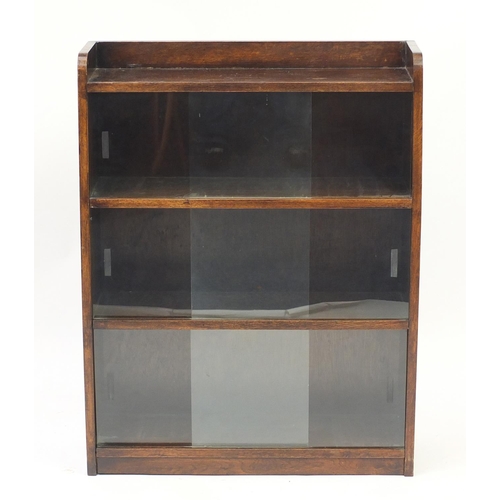 21 - Oak bookcase with sliding glass doors, 92cm H x 71cm W x 22cm D