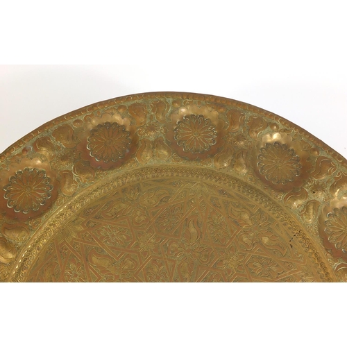 69 - Indian brass tray topped folding table, 46cm high x 56cm in diameter