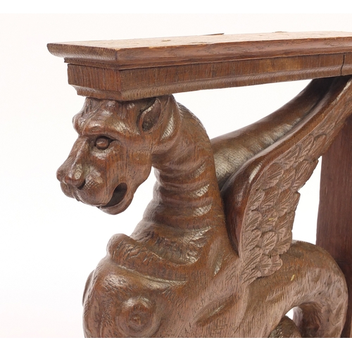 68 - Pair of carved oak griffin brackets, 38cm high