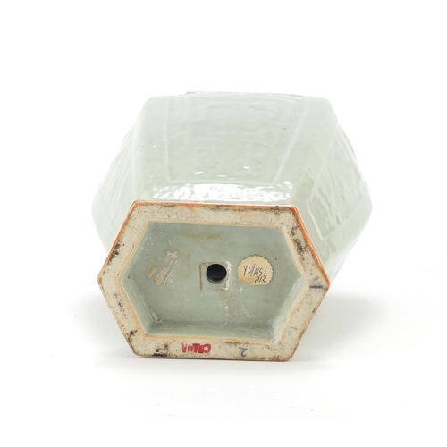 2323 - Chinese hexagonal celadon glazed vase raised on hardwood stand, decorated in low relief with panels ... 