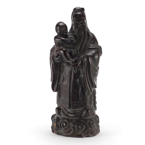 2312 - Chinese hardwood carving of an elder holding a child above clouds, 39cm high