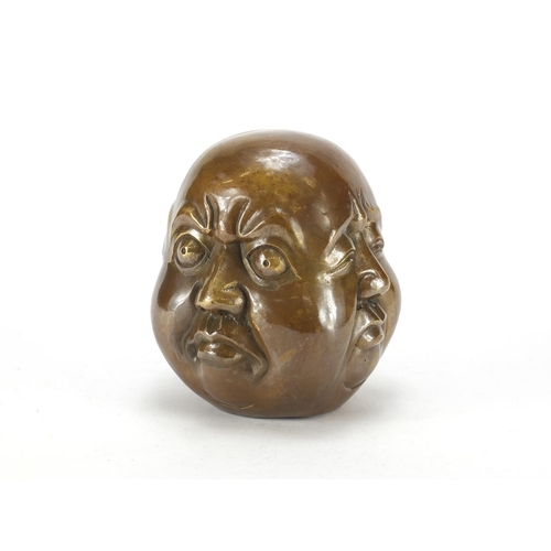 2055 - Chinese patinated bronze four sided Buddha head paperweight, character marks to the base, 15cm high
