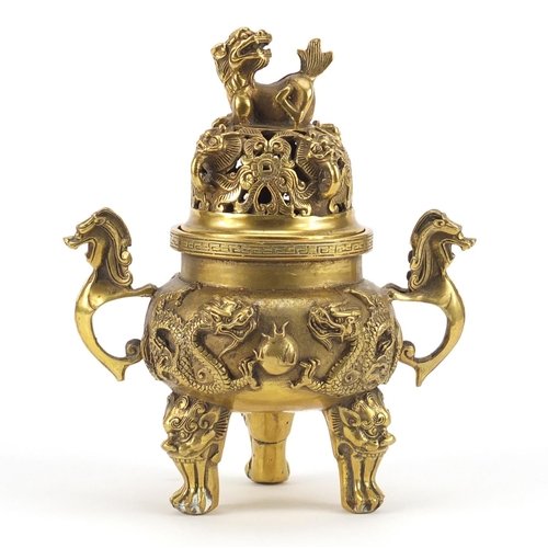 2218 - Chinese gilt tripod censer and cover with twin handles, decorated in relief with dragons chasing the... 