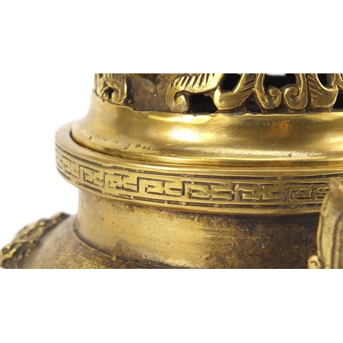 2218 - Chinese gilt tripod censer and cover with twin handles, decorated in relief with dragons chasing the... 
