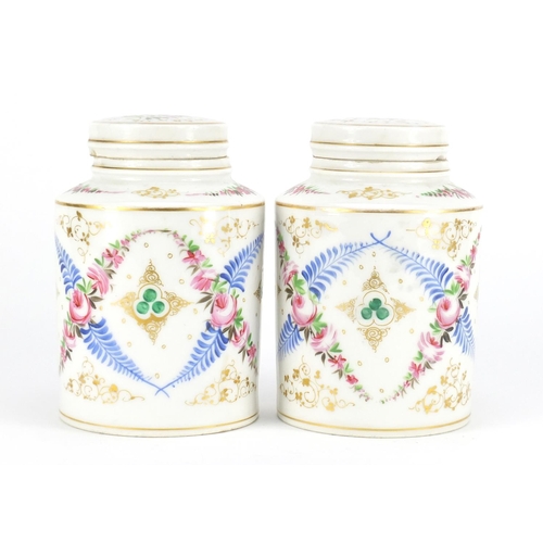 2201 - Pair of continental porcelain canisters with covers, hand painted and gilded with flowers, 17cm high