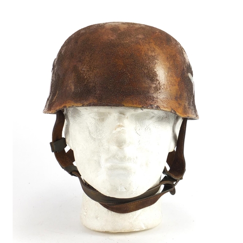 2468 - German Military interest tin helmet with decals and leather liner, impressed marks to the interior
