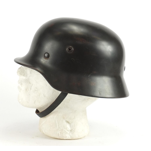 2466 - German Military interest tin helmet with decal and leather liner, impressed marks to the interior