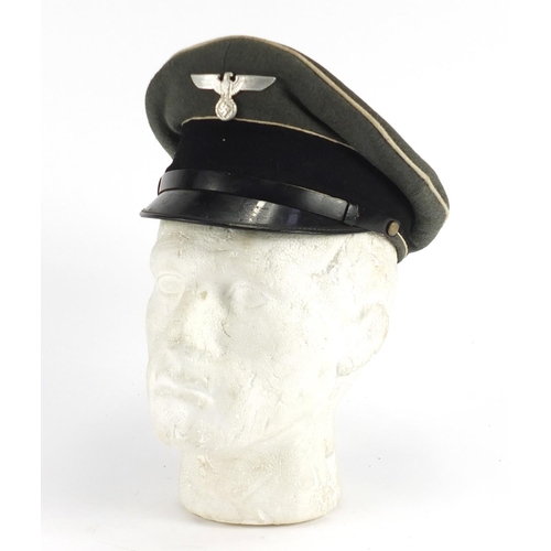2470 - German Military interest visor cap with badges and part label to the interior