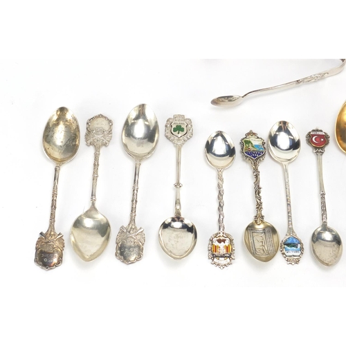 2516 - Mostly silver souvenir teaspoons, a set of three silver rifle club teaspoons and a pair of sugar ton... 
