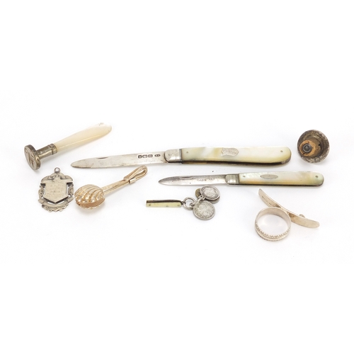 2526 - Silver objects including two mother of pearl folding pocket knives, Maundy coin charm and a tie clip