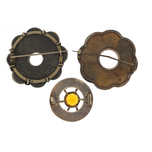 676 - Two Scottish unmarked silver agate brooches and one other, one set with semi precious stones, the la... 