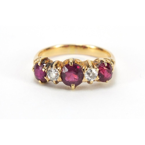 664 - Unmarked gold, ruby and diamond five stone ring with scroll settings, size L, 3.1g