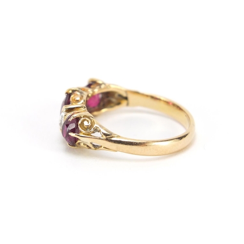 664 - Unmarked gold, ruby and diamond five stone ring with scroll settings, size L, 3.1g