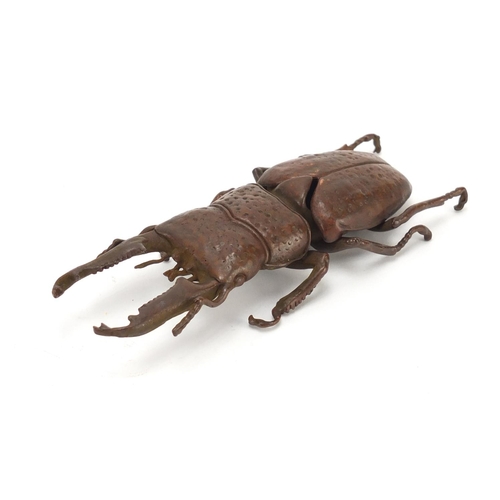 402 - Japanese patinated bronze stag beetle with articulated wings, impressed marks to the underside, 13cm... 