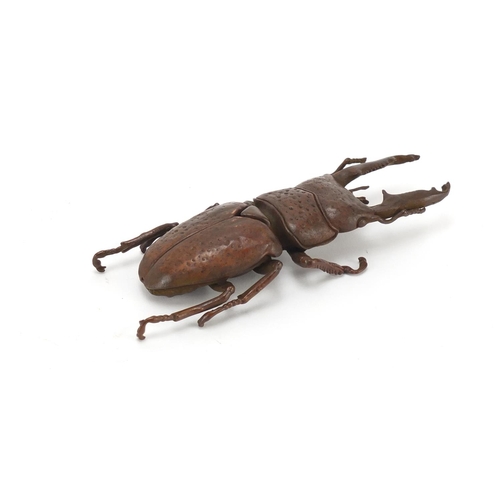 402 - Japanese patinated bronze stag beetle with articulated wings, impressed marks to the underside, 13cm... 