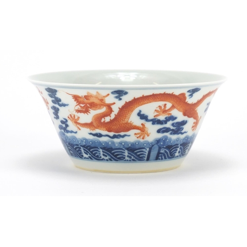 336 - Chinese blue and white porcelain bowl, hand painted in iron red with dragons amongst clouds chasing ... 