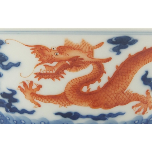 336 - Chinese blue and white porcelain bowl, hand painted in iron red with dragons amongst clouds chasing ... 