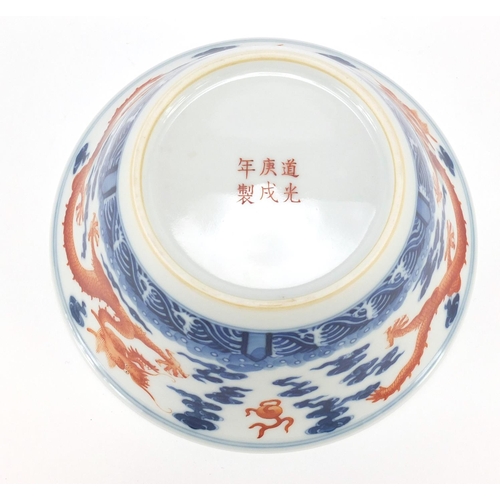 336 - Chinese blue and white porcelain bowl, hand painted in iron red with dragons amongst clouds chasing ... 