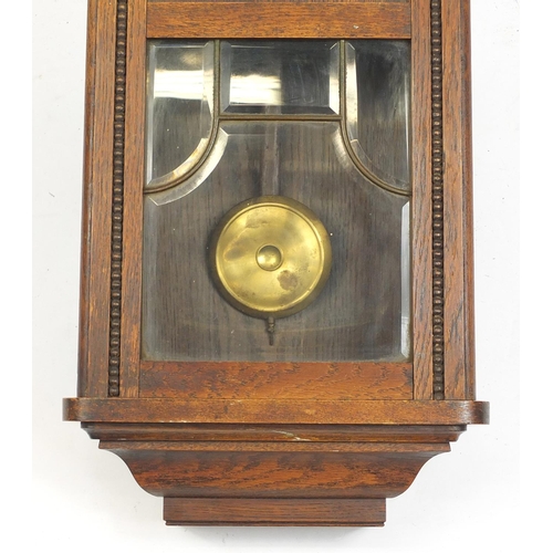 56 - Oak cased wall hanging clock striking on a gong, 80cm high