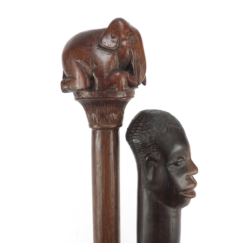 120 - Two African walking sticks with carved elephant head and figural pommels, the largest 91cm in length