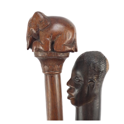 120 - Two African walking sticks with carved elephant head and figural pommels, the largest 91cm in length