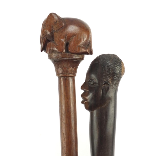 120 - Two African walking sticks with carved elephant head and figural pommels, the largest 91cm in length