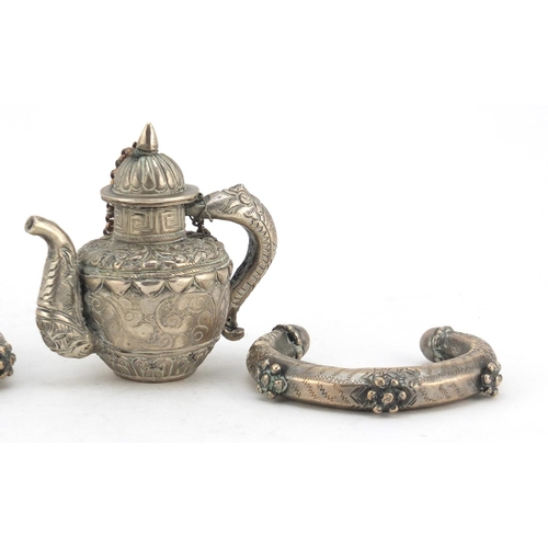 616 - Tibetan Unmarked silver miniature teapot and two silver coloured metal slave bangles, the teapot 7cm... 